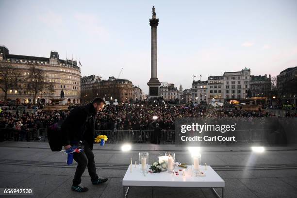 Man lays flowers during a candlelit vigil at Trafalgar Square on March 23, 2017 in London, England. Four People were killed in Westminster, London,...
