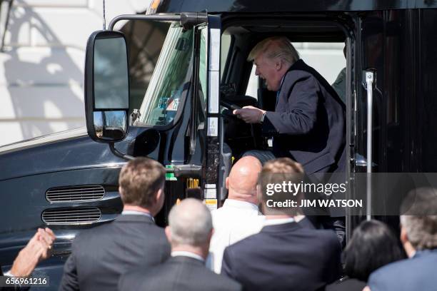 President Donald Trump sits in the drivers seat of a semi-truck as he welcomes truckers and CEOs to the White House in Washington, DC, March 23 to...