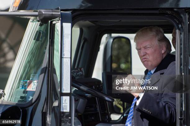 President Donald Trump sits in the drivers seat of a semi-truck as he welcomes truckers and CEOs to the White House in Washington, DC, March 23 to...