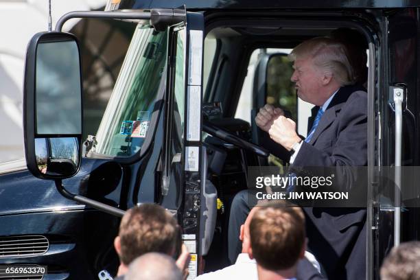 President Donald Trump sits in the drivers seat of a semi-truck as he welcomes truckers and CEOs to the White House in Washington, DC, March 23 to...