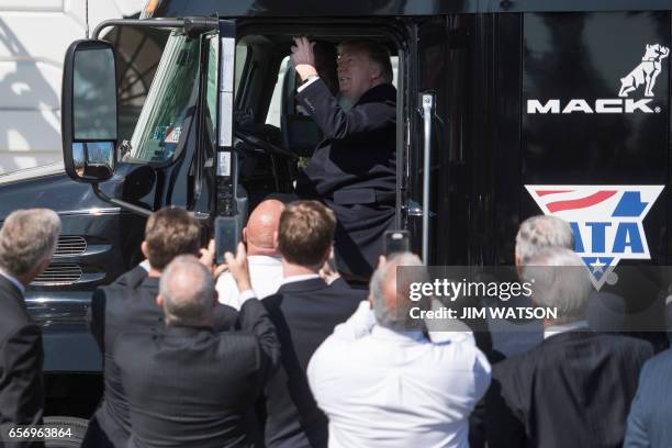 President Donald Trump pulls the horn as he sits in the drivers seat of a semi-truck while welcoming truckers and CEOs to the White House in...