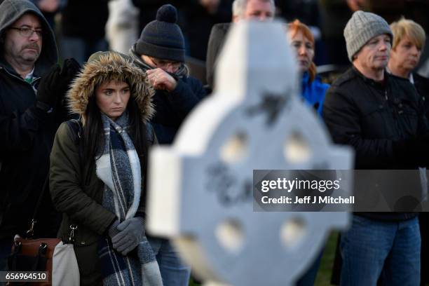 Mourners look on during Martin McGuinness' Funeral at the Derry City Cemetery on March 23, 2017 in Londonderry, Northern Ireland. The funeral is held...