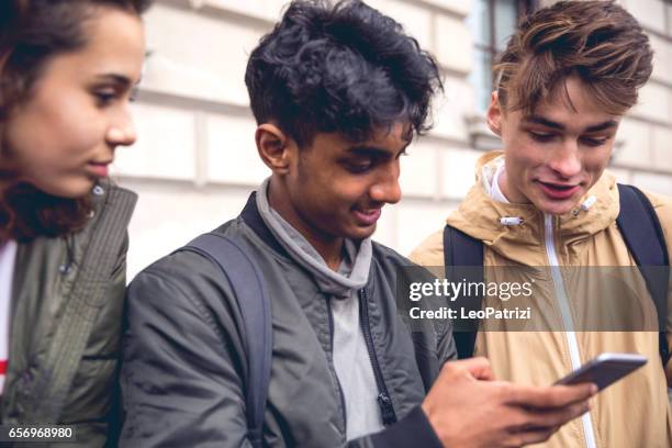 studenten chatten op mobiele telefoon - tienerjongens stockfoto's en -beelden