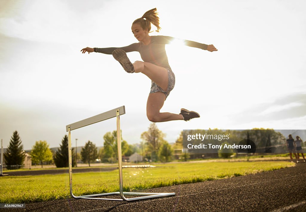 Young woman hurdler on school track