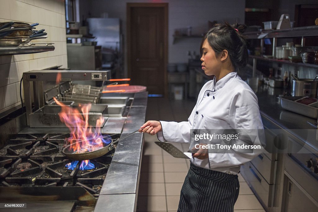 Young woman chef in restaurant kitchen