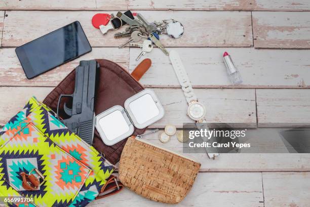 flat lay  woman´s bag with  gun and feminine items - inside handbag stock pictures, royalty-free photos & images