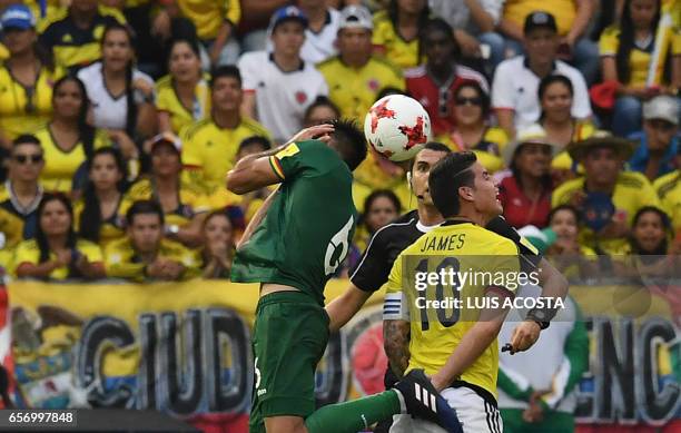 Bolivia's midfielder Danny Bejarano and Colombia's midfielder James Rodriguez jump for a header as Brazilian referee Ricardo Marques Ribeiro looks on...