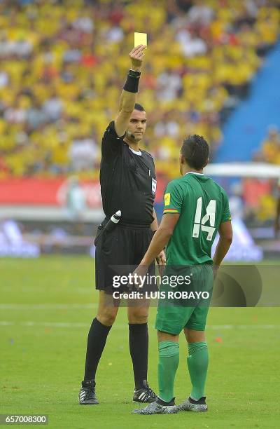 Referee Ricardo Marques Ribeiro shows a yellow card to Bolivia's defender Juan Aponte during their 2018 FIFA World Cup qualifier football match...