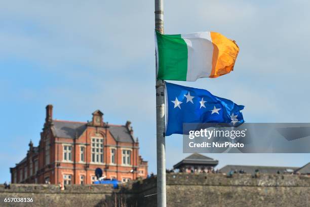 Irish tricolore and Irish Nationalist flags fly at half-staff as the coffin of former Northern Ireland Deputy First Minister Martin McGuinness passes...