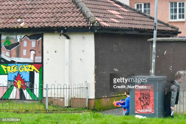 Local children play with a plastic guns just minutes before the coffin of former Northern Ireland Deputy First Minister Martin McGuinness passes by...