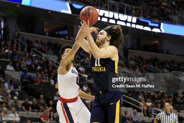 Silas Melson of the Gonzaga Bulldogs and Nathan Adrian of the West Virginia Mountaineers vie for posession in the first half during the 2017 NCAA...