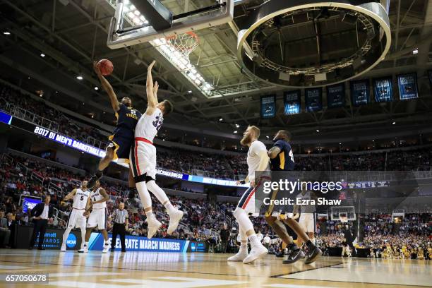 Jevon Carter of the West Virginia Mountaineers goes up against Zach Collins of the Gonzaga Bulldogs in the first half during the 2017 NCAA Men's...