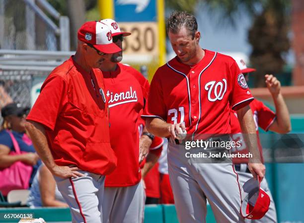 Pitching Coach Mike Maddux talks to Max Scherzer prior to starting the spring training game against the St Louis Cardinals at Roger Dean Stadium on...
