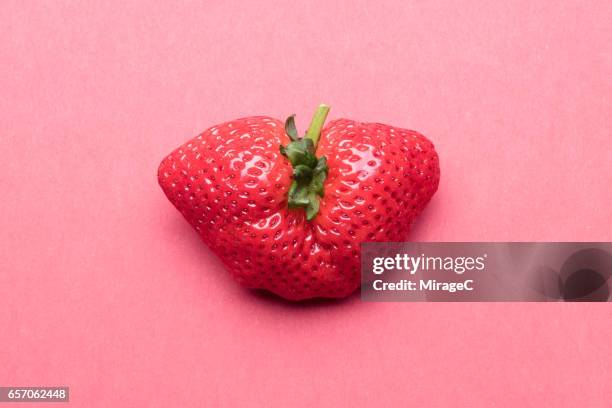 bizarre misshapen strawberry - ugliness stock-fotos und bilder