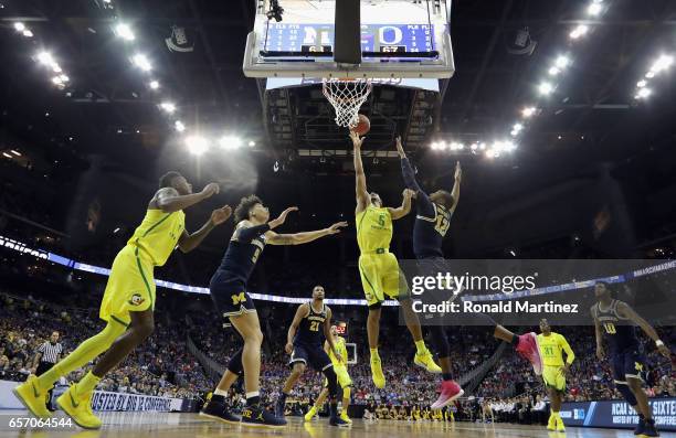 Tyler Dorsey of the Oregon Ducks battles for the ball with D.J. Wilson and Muhammad-Ali Abdur-Rahkman of the Michigan Wolverines in the second half...