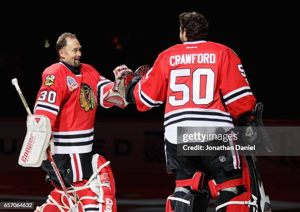 Former Chicago Blackhawks goaltender Ed Belfour greets Corey Crawford as he is honored before a game against the Dallas Stars at the United Center on...