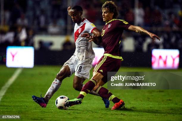 Peru's forward Andre Carrillo vies for the ball with Venezuela's defender Rolf Feltscher during their 2018 FIFA World Cup qualifier football match in...