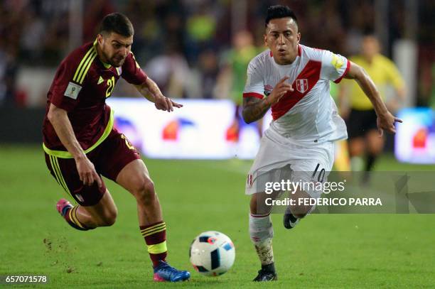 Venezuela's defender Alexander Gonzalez vies for the ball with Peru's forward Christian Cueva during their 2018 FIFA World Cup qualifier football...