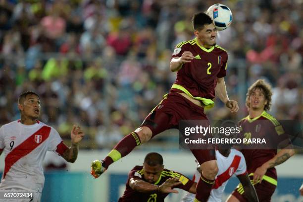 Venezuela's defender Wilker Angel jumps for the ball next to Peru's forward Paolo Guerrero during their 2018 FIFA World Cup qualifier football match...