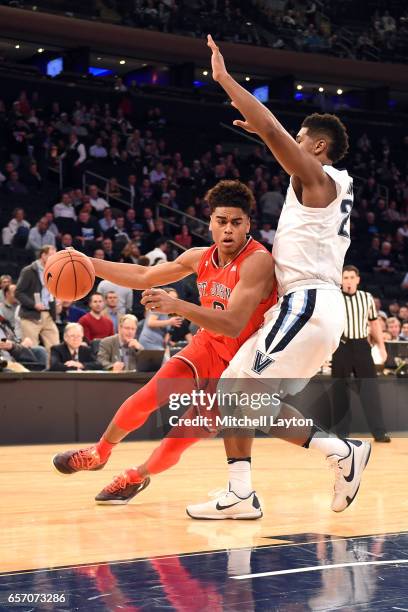 Malik Ellison of the St. John's Red Storm dribbles by Kris Jenkins of the Villanova Wildcats during the Big East Basketball Tournament - Quarterfinal...