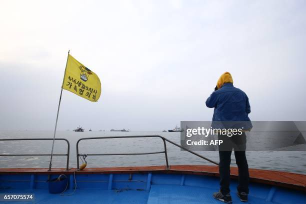 Relative of a victim watches the ongoing salvage operation of the Sewol ferry off the coast of South Korea's southern island of Jindo on March 24,...