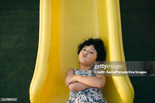 girl playing on slide - slide play equipment stock pictures, royalty-free photos & images