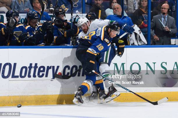 Jay Bouwmeester of the St. Louis Blues checks Jack Skille of the Vancouver Canucks off of the puck on March 23, 2017 at Scottrade Center in St....