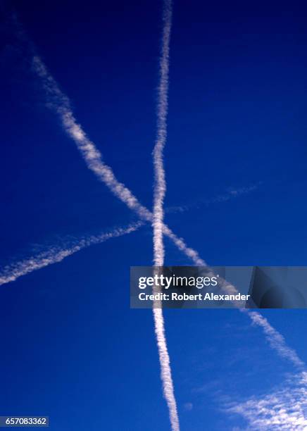 Contrails left by jet aircraft streak the sky over Santa Fe, New Mexico. While the contrails might appear to show a 'near miss' between two aircraft,...