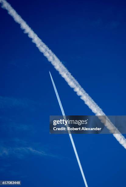 Contrails left by jet aircraft streak the sky over Santa Fe, New Mexico. While the contrails might appear to show a 'near miss' between two aircraft,...