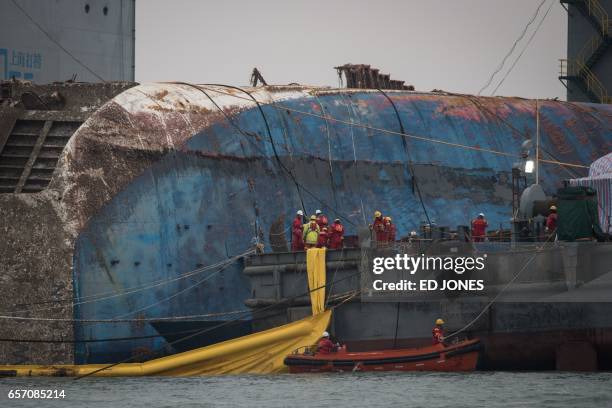 Workers aboard a Chinese salvage vessel participate in the salvage operation of the Sewol ferry off the coast of South Korea's southern island of...