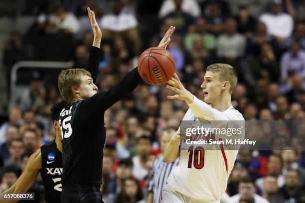 Lauri Markkanen of the Arizona Wildcats passes against J.P. Macura of the Xavier Musketeers in the first half during the 2017 NCAA Men's Basketball...