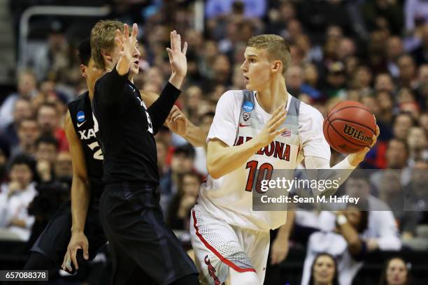 Lauri Markkanen of the Arizona Wildcats passes against J.P. Macura of the Xavier Musketeers in the first half during the 2017 NCAA Men's Basketball...