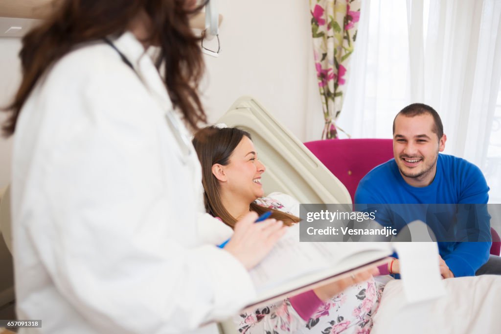 Doctor Talking To Pregnant Woman And Her Husband