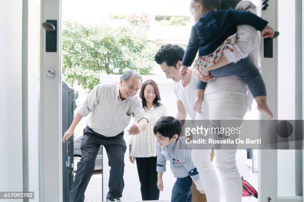 young family welcoming grandparents at home - baby arrival stock pictures, royalty-free photos & images