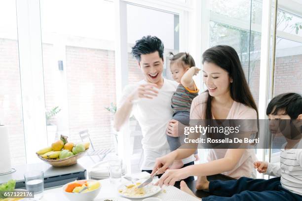 young family having breakfast in the kitchen - young family in kitchen stock pictures, royalty-free photos & images