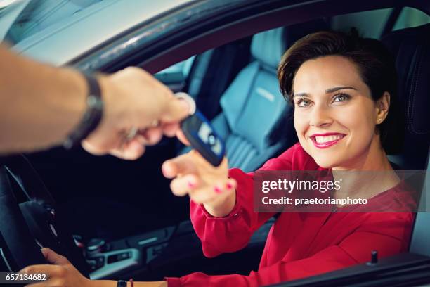 car dealer is giving car key to a businesswoman - luxury cars stock pictures, royalty-free photos & images