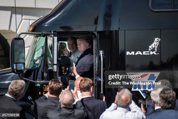 President Donald Trump jumps up in the cab of an 18 wheeler truck while meeting with truckers and CEOs regarding healthcare on the South Lawn of the...