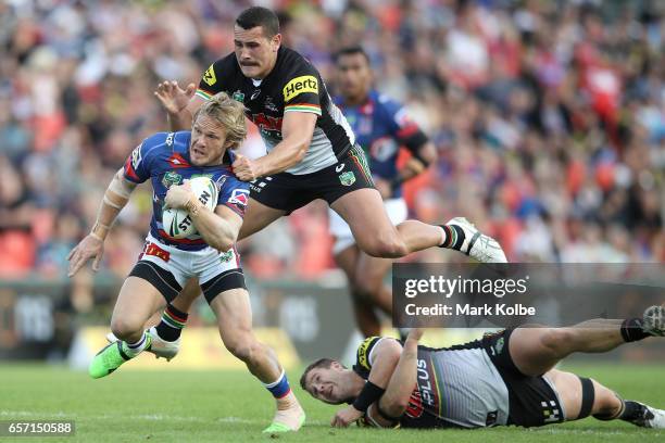 Nathan Ross of the Knights is tackled by Reagan Campbell-Gillard of the Panthers as he jumps over Trent Merrin of the Panthers during the round four...