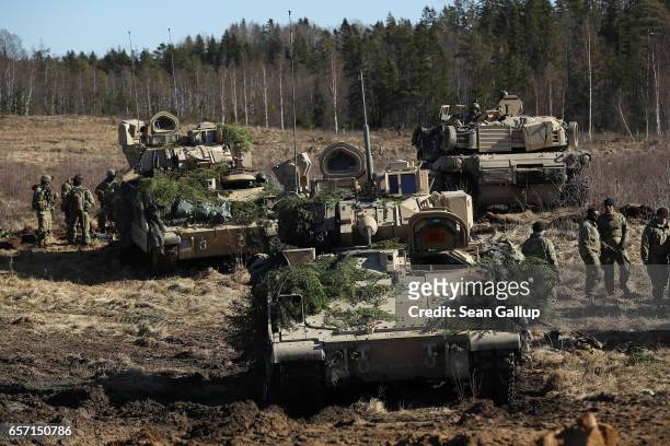 Members of Chaos Company, 1-68 Armor Battalion of the 3rd Brigade Combat Team, 4th Infantry Division, stand near their M2A3 Bradley fighting vehicles...