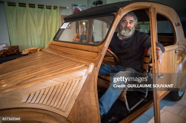 French cabinetmaker Michel Robillard poses in his handbuilt wooden 2CV Citroen Car built as an exact one/one replica on March 20 near Loches, Central...