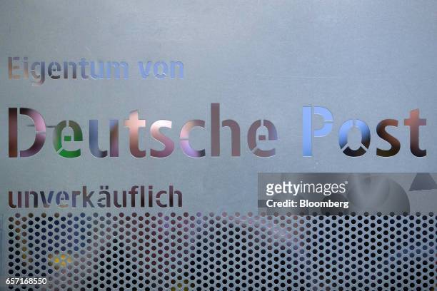 Logo sits on the side of a parcel container inside a Deutsche Post AG delivery station in Hamburg, Germany, on Tuesday, March 7, 2017. With car...