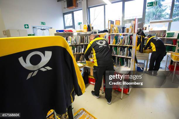 Postal workers sort parcels and letters inside a Deutsche Post AG delivery station in Hamburg, Germany, on Tuesday, March 7, 2017. With car makers...