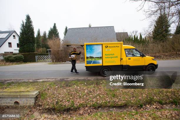 Deutsche Post AG employee uses a StreetScooter emission-free electric light commercial vehicle , to make a postal delivery in Hamburg, Germany, on...