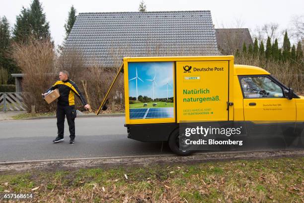 Deutsche Post AG employee uses a StreetScooter emission-free electric light commercial vehicle , to make a postal delivery in Hamburg, Germany, on...