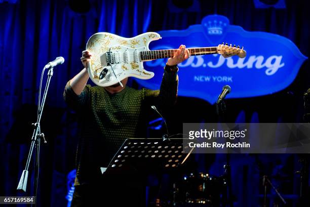 Justin Loeber holds a guitar with signatures of all the nights performers during "Beat The Blues To Save Lives" Charity Concert at BB King on March...