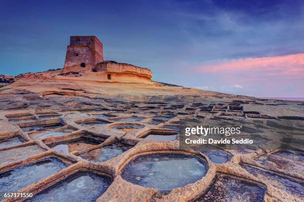 malta, gozo island, xlendi, watchtower and salt pans at sunset - gozo malta fotografías e imágenes de stock