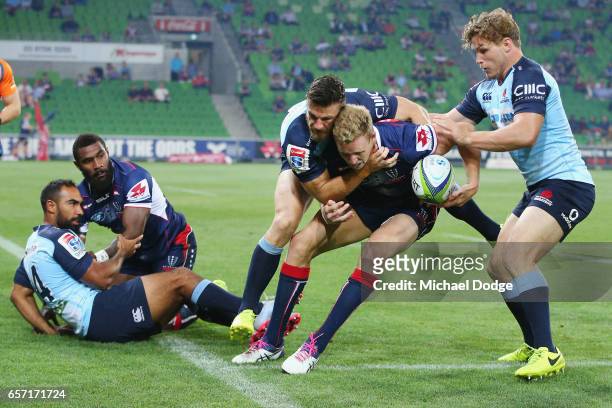 Reece Hodge of the Rebels is tackled by Rob Horne of the Waratahs during the round five Super Rugby match between the Rebels and the Waratahs at AAMI...