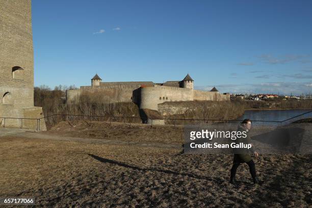 Visitor walks on the grounds of Hermann Castle and opposite Ivangorod Fortress , which is on the Russian side the Narva River that flows below, on...