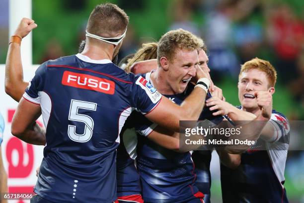 Reece Hodge of the Rebels celebrates a try with teammates during the round five Super Rugby match between the Rebels and the Waratahs at AAMI Park on...