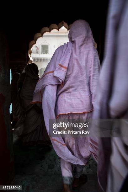 widows leave the temple backyard after the celebration is over. - widow stock pictures, royalty-free photos & images